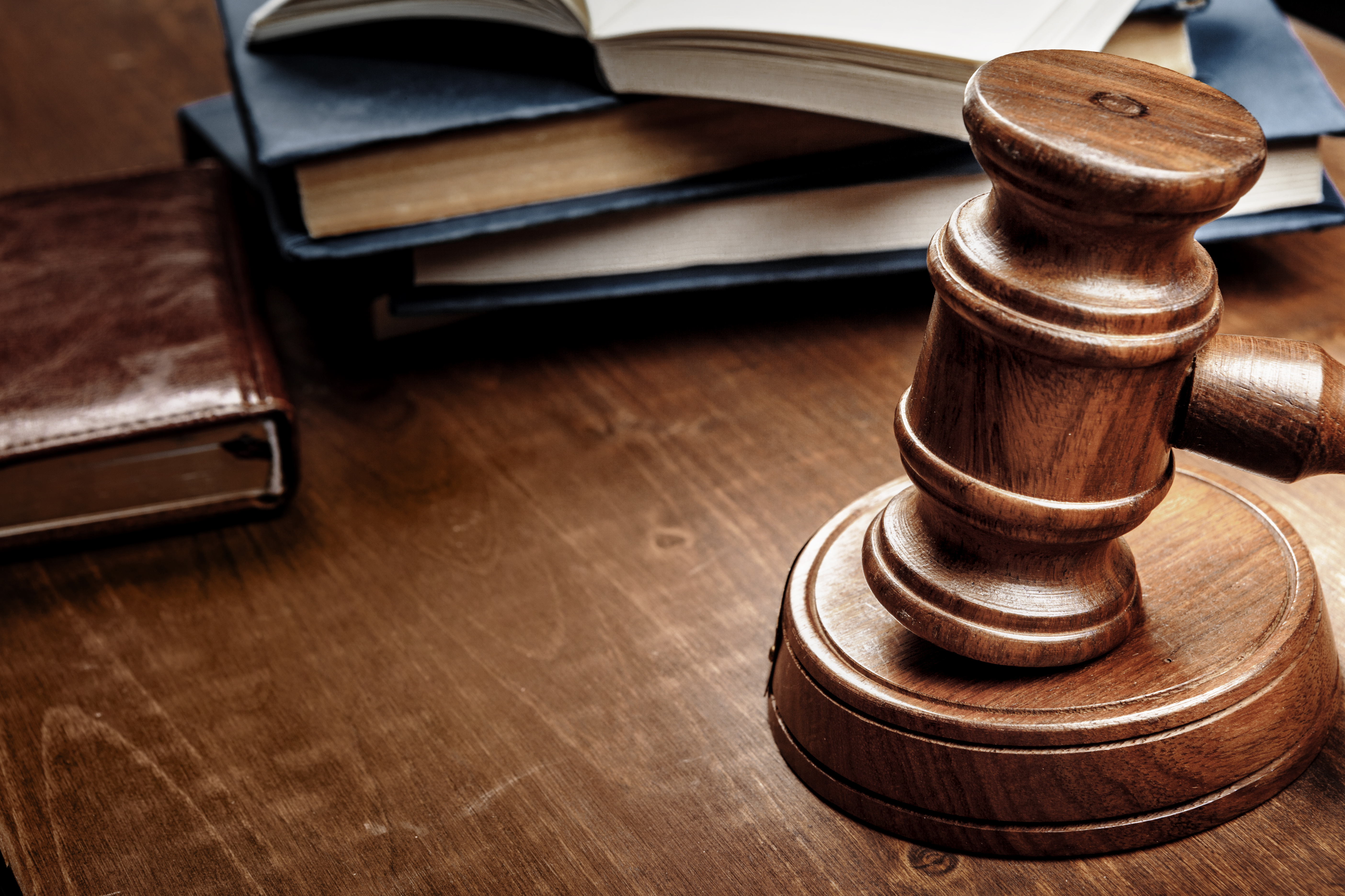Brown wooden judge mallet on the background of open book